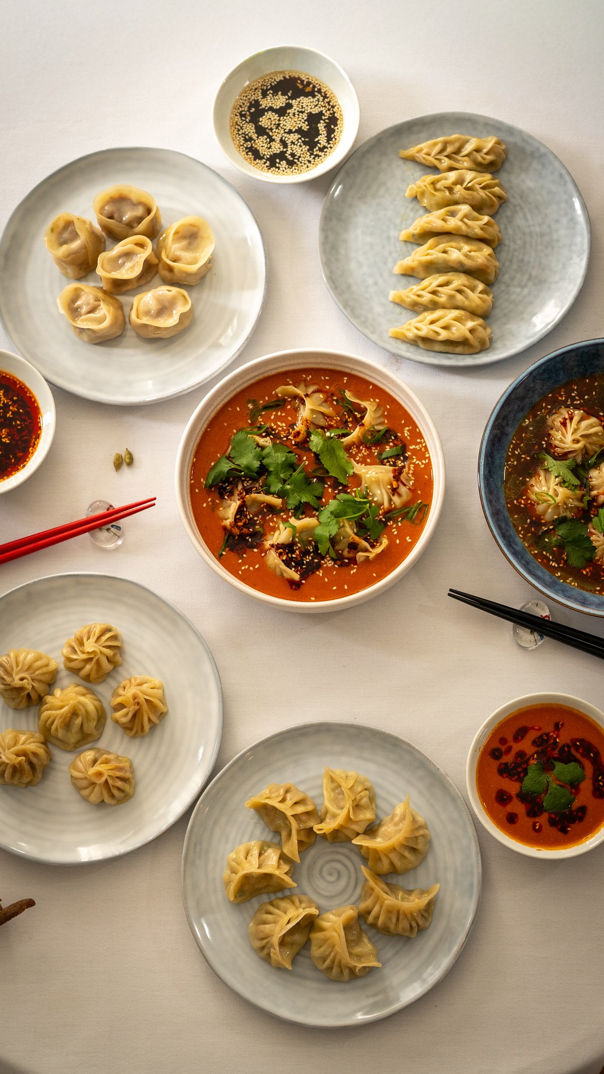 A table spread of handmade dumplings with house sauces and soups